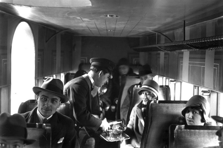 Des passagers se font servir des boissons dans un avion de l'Union aérienne française en 1929