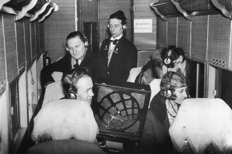 Des passagers écoutent une émission à bord d'un vol en 1931