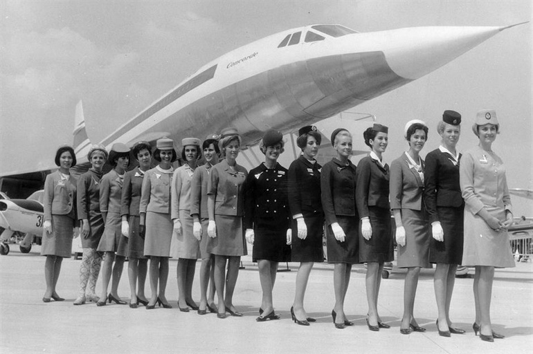 Des hôtesses de l'air font la queue devant une maquette du Concorde dans les années 1960