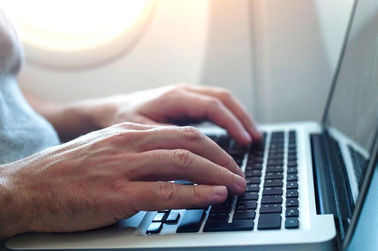 Un homme travaille sur son ordinateur portable pendant un vol